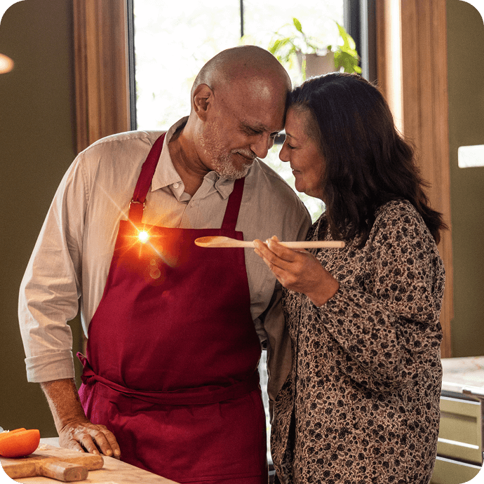 Two adults standing together in a kitchen preparing food