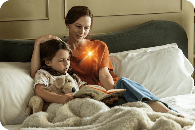 Adult and child reading together on a bed in a calm home setting