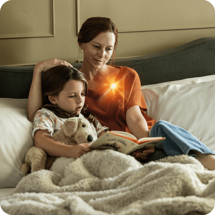 Adult and child reading together on a bed in a calm home setting