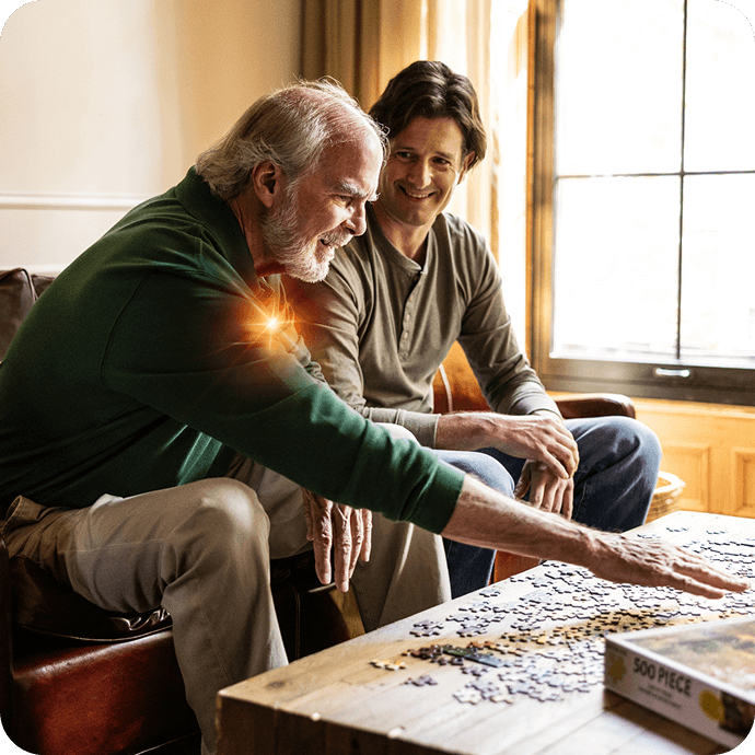 Two adults sitting together at a table working on a puzzle at home